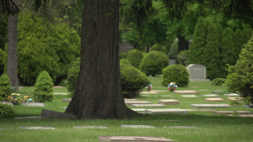 Older man putting US flag in a grave