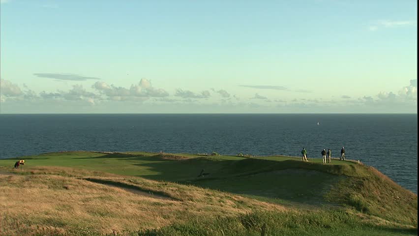 foursome teeing off on cliff overlooking Irish sea, Kinsale, Ireland