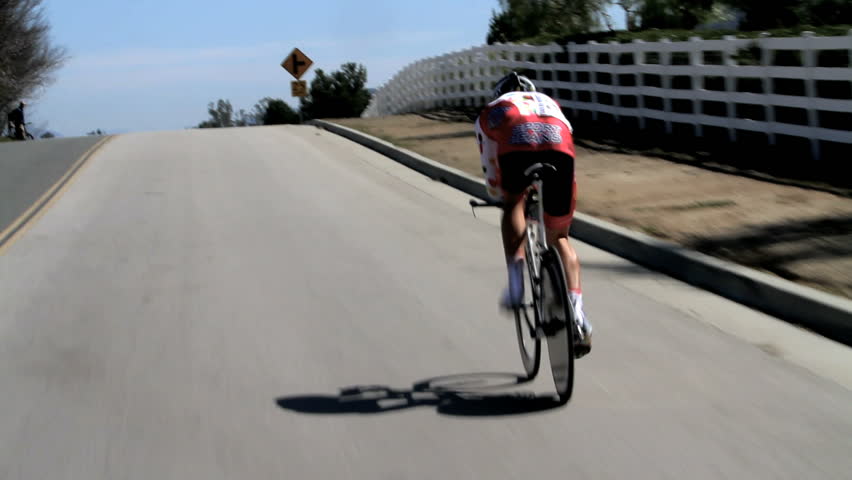 California - Circa 2009: A bike race in 2009. The rear view of lone cyclist going up hill in a race in California.