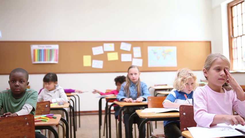 Pupils raising their hands in the classroom