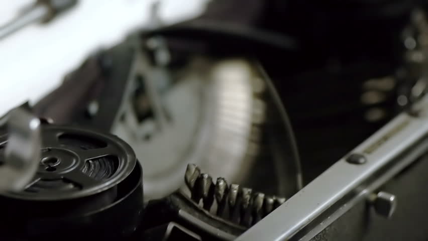 Typing on Vintage Typewriter (HD). Typing on Vintage 1940s typewriter seen from an angle with shallow depth of field ink roll seen moving. Ambient audio Included.