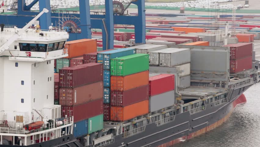 Lot of containers on board of barge and at shore of port