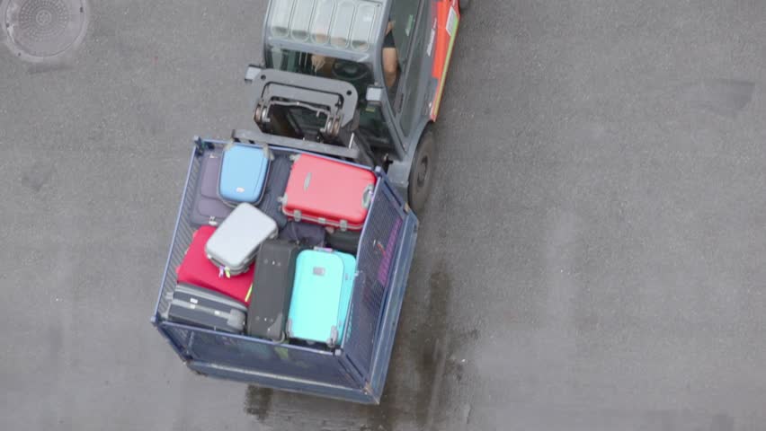 Loader moves tray with passengers luggage, view from above