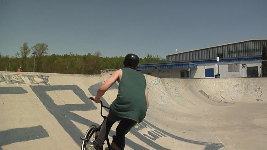 BMXer does a crazy transfer at a skatepark