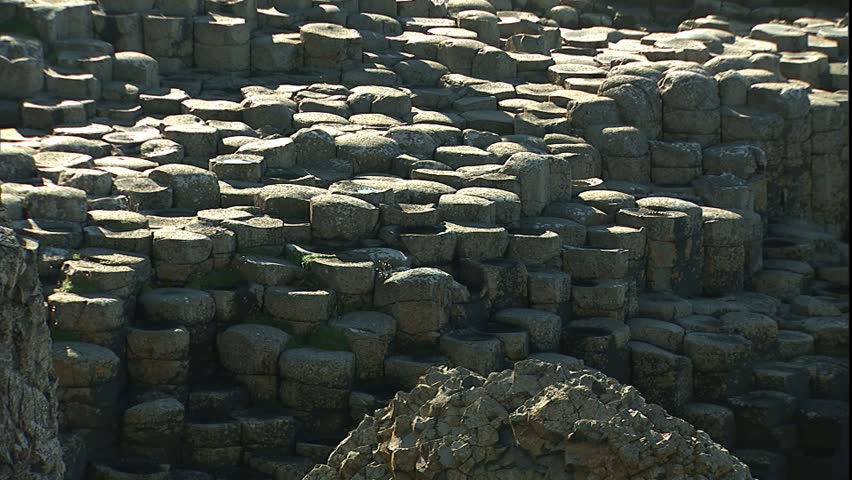 COLERAINE, NORTHERN IRELAND - CIRCA 2000: Pan right and left across basalt columns and visitors at Giant's Causeway