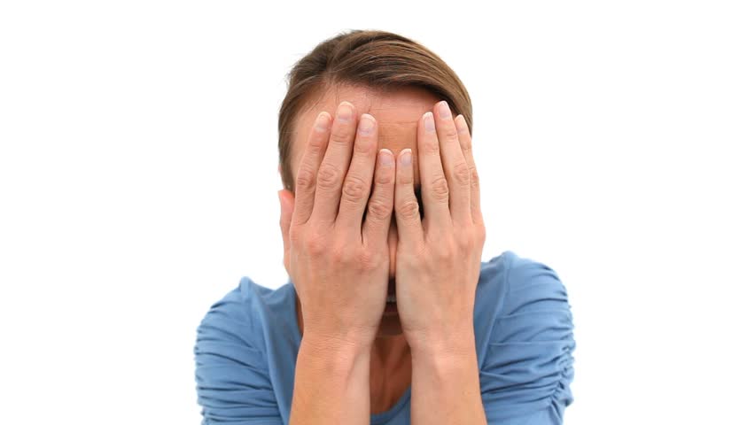 Woman hiding her face with her hands against white background