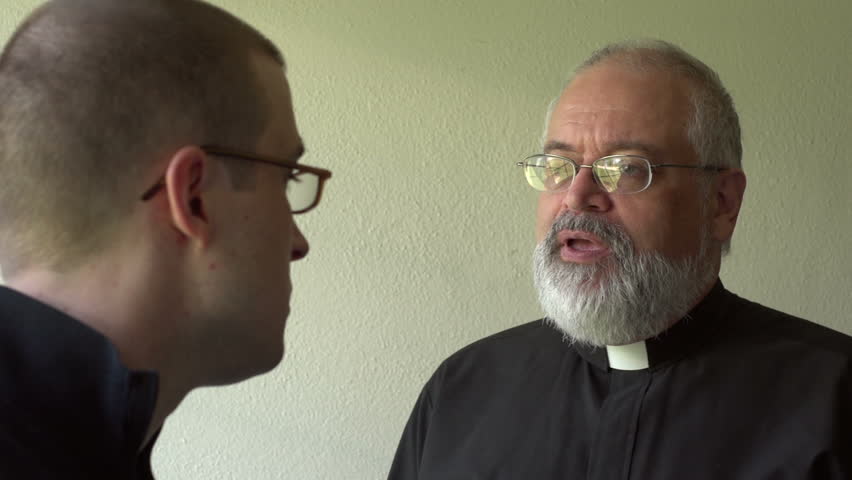 Priest talking with parishioner in a church