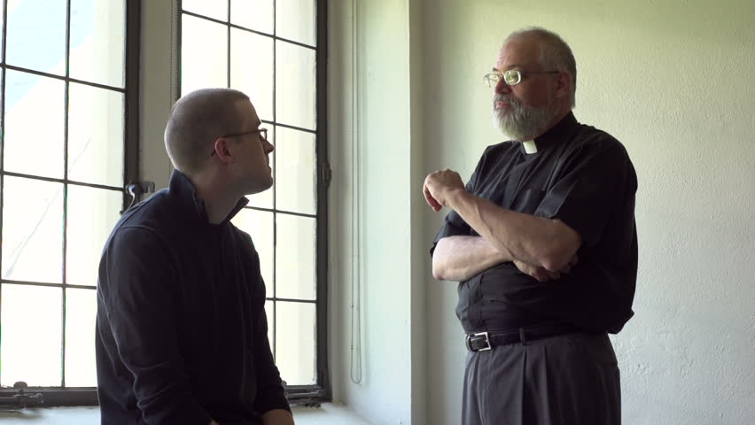 Priest talking with parishioner in a church