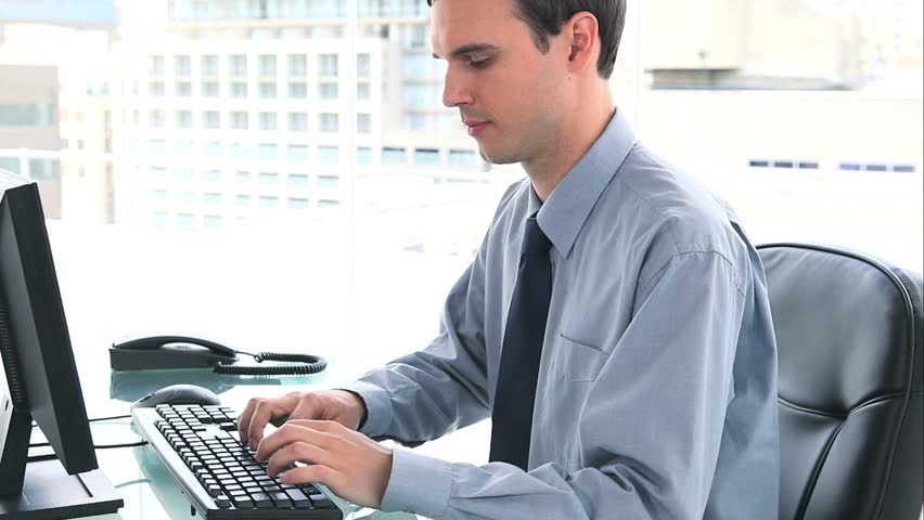 Smiling businessman picking up the phone in his office