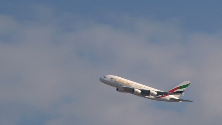 Dubai - Circa 2012: An Emirates airplane in 2012. An Emirates plane soaring over the city of Dubai, United Arab Emirates.
