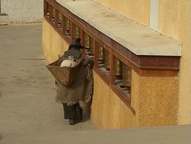Buddhist pilgrim - old woman rotating turning praying wheels in monastery (Ladakh, Jammu & Kashmir)