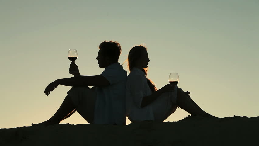 Peaceful lovers drinking red wine at sunset