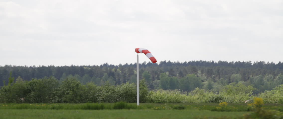 Windsock at the airport in Latvia. Wind blowing towards the camera, and to the right.