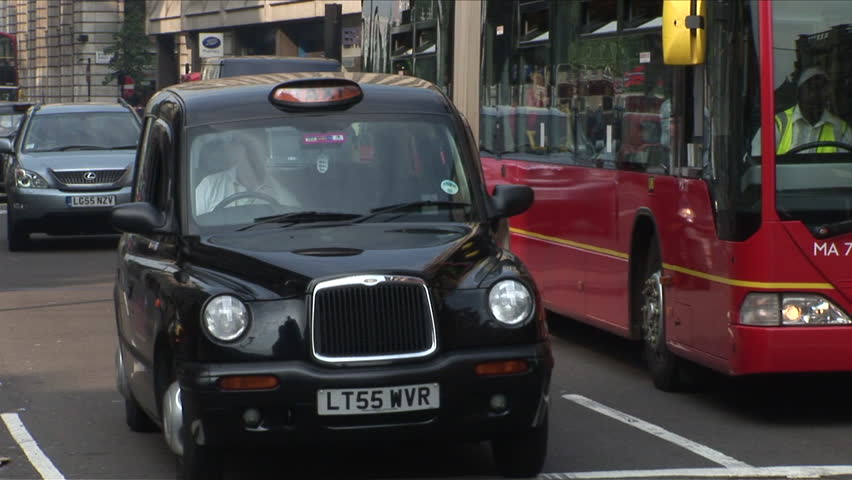 London, England - CIRCA June, 2006: Taxis and buses go down a busy street during the day