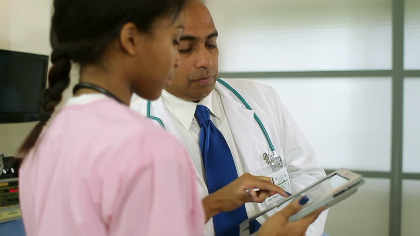 Nurse informs the doctor of a patients test results using an electronic tablet pc.