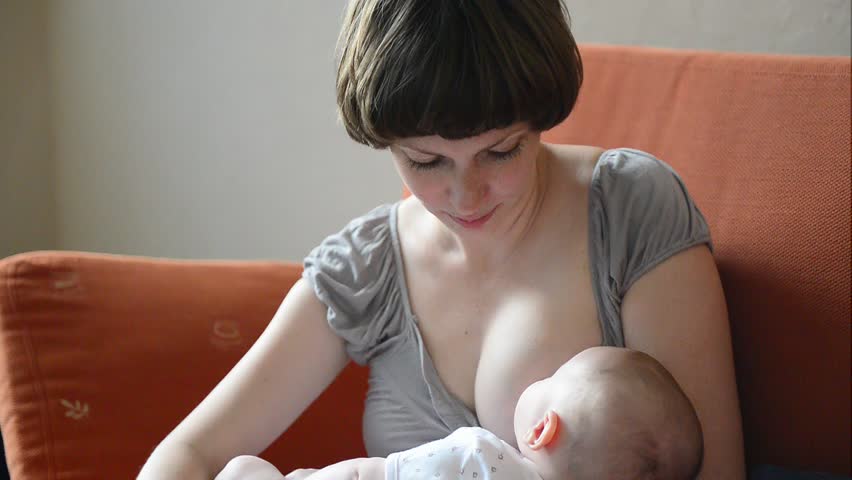 Young beautiful Mother breastfeeding her newborn baby