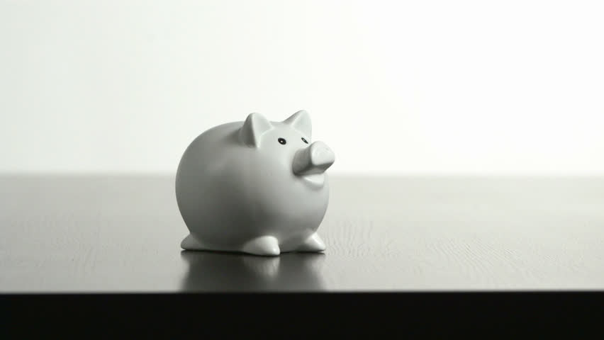 Studio shot of 10 kg weight falling on piggybank