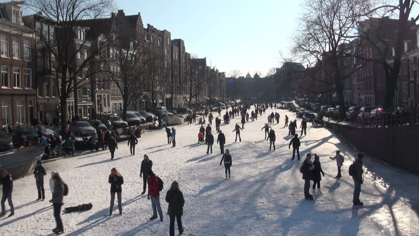 AMSTERDAM - FEBRUARY 11 2012: People are enjoying a beautiful sunny day on the ice in the heart of Amsterdam, capital city of the Netherlands