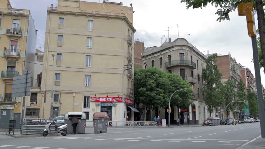 BARCELONA - MAY 26, 2012:  City traffic, homeless man is digging in rubbish, people walking around.