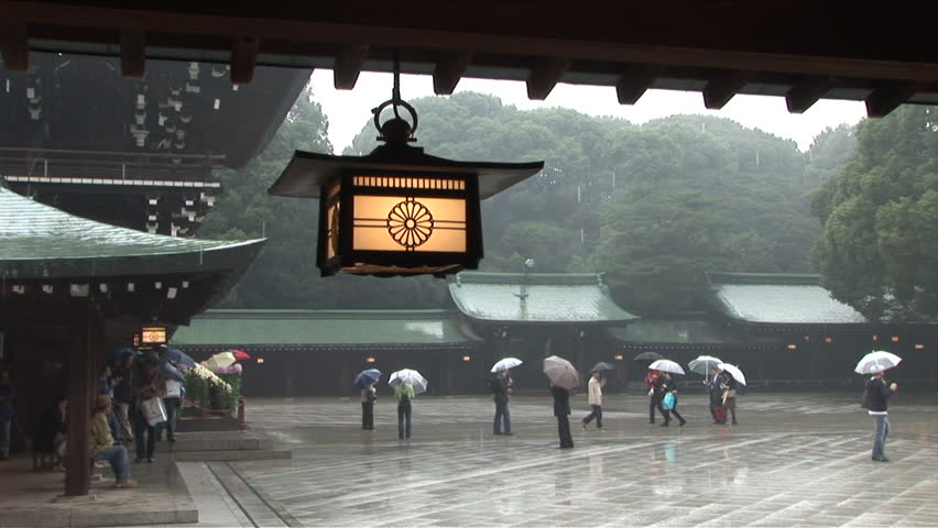 Tokyo, Japan - CIRCA November, 2006: Tourists holding umbrellas visit an old temple during a rainy day