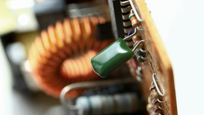 Macro of hand unsoldering and pulling out condenser from circuit board