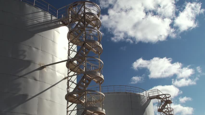 The worker up the stairs to the huge oil tanker
