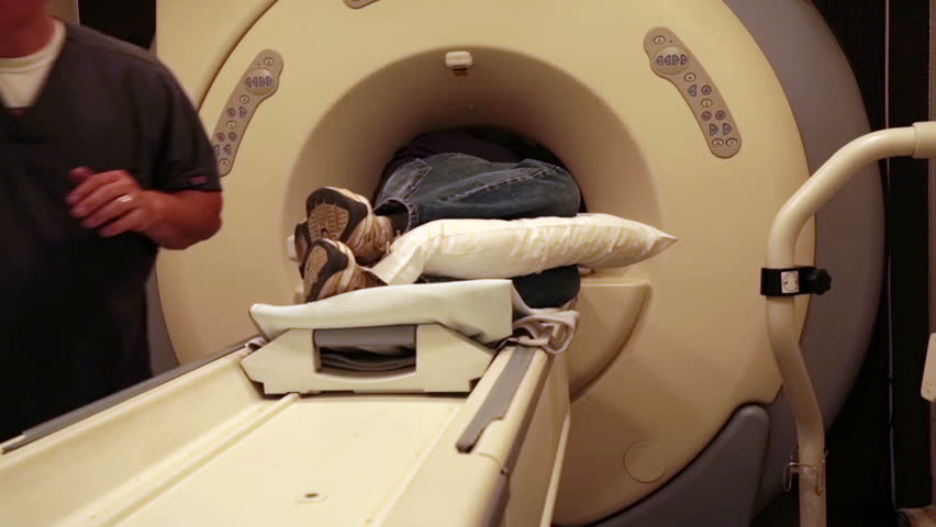 Hospital ER emergency MRI image scan man. Man lays in Magnetic Resonance Image device to look deep into soft muscles and bones. Injury diagnostic before surgery. Doctor and radiologist clinical exam. 