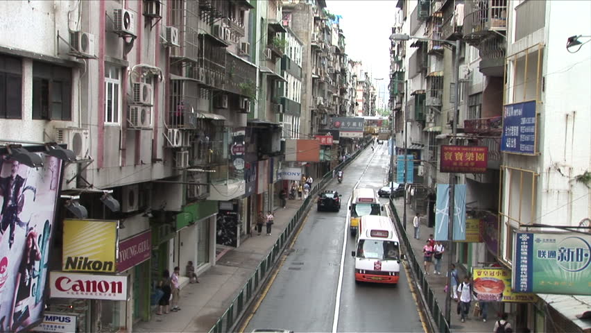 Macau, China - CIRCA March, 2007: A crowded commercial street with cars and pedestrians interacting in harmony