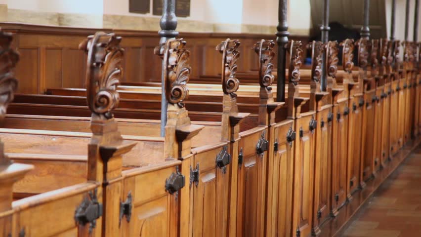 Mother with two her kids boy and little girl walk near row of benches in cathedral