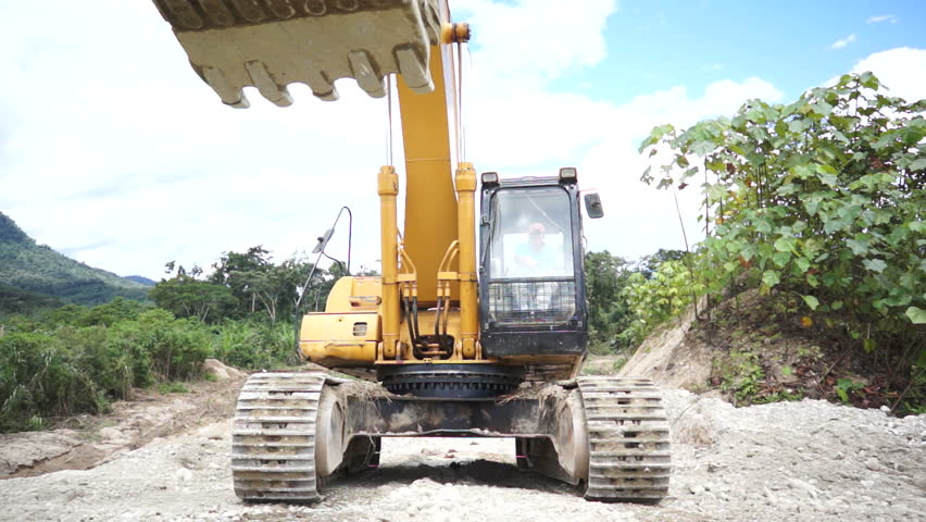Heavy equipment excavator running over the camera or viewer.