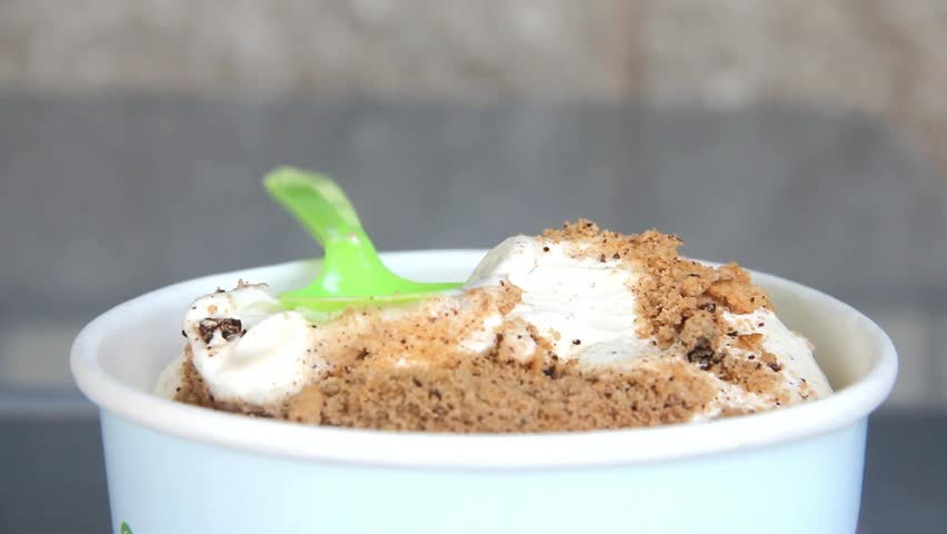 Ice Cream With Cookie Crumbs In A Bowl Eaten With A Plastic Spoon