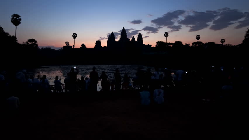 ANGKOR WAT, CAMBODIA - CIRCA MAY 2011: Dawn over the Temple of Angkor Wat watched by many tourists.