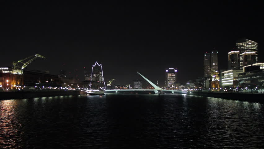 Puerto Madero harbor, Buenos Aires, at night. Scenic view including the landmark Puente de la Mujer footbridge. Puerto Madero is an upscale district and also popular among tourists (Jul 2012).