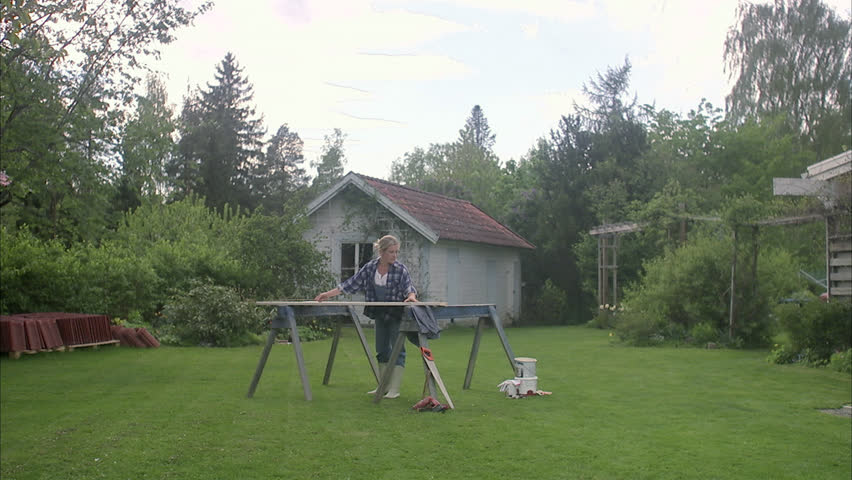 A woman doing carpentry in a garden