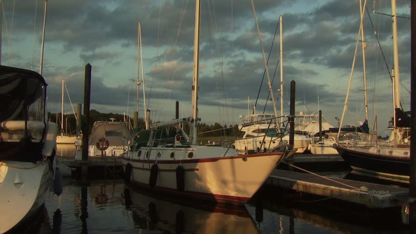 NEWPORT, RHODE ISLAND - CIRCA AUGUST 2007: Passing by sailboats and motor boats moored at dock at sunset