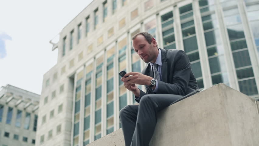 Young handsome businessman with smartphone in the city
