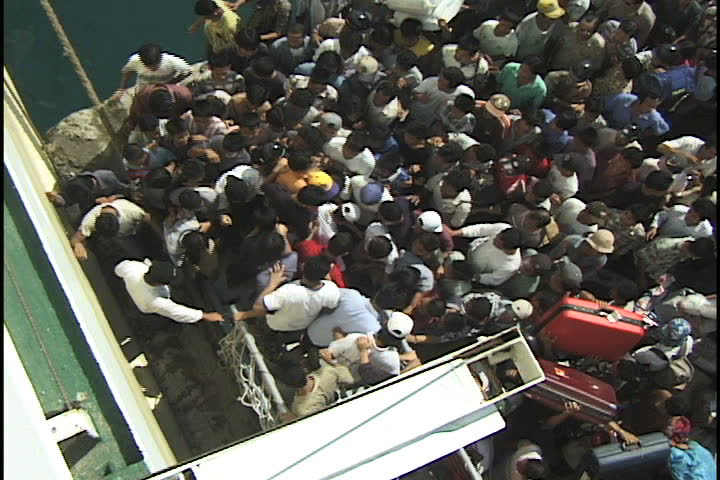NIAS ISLAND, INDONESIA - CIRCA SEPT 1999: Crowd of Indonesians push and shove to get on board ferry boat from Nias Island to Sibolga, Indonesia. 