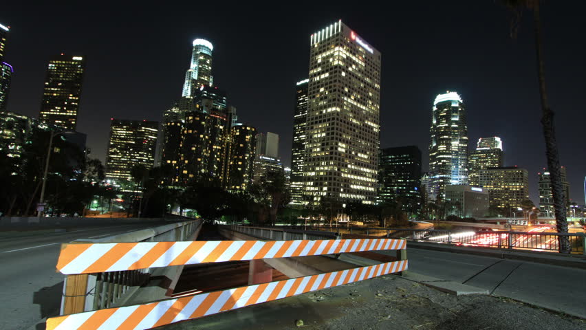 Amazing time lapse rising shot from a crane over a busy Los Angeles freeway and overpass. 