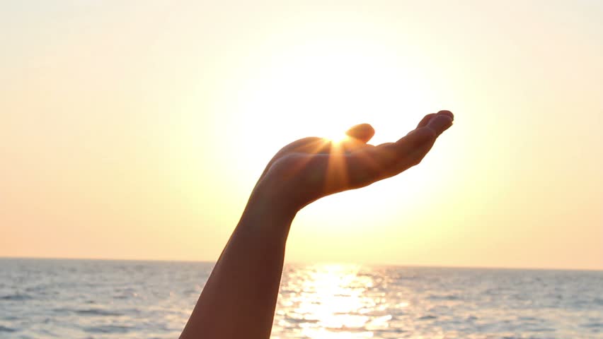 Woman hides the sun in hand