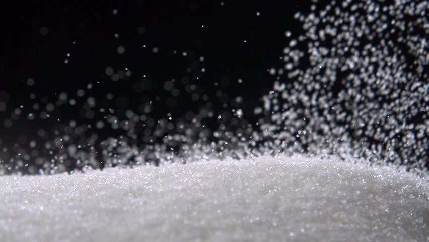 Pile of sugar on black background shooting with high speed camera.