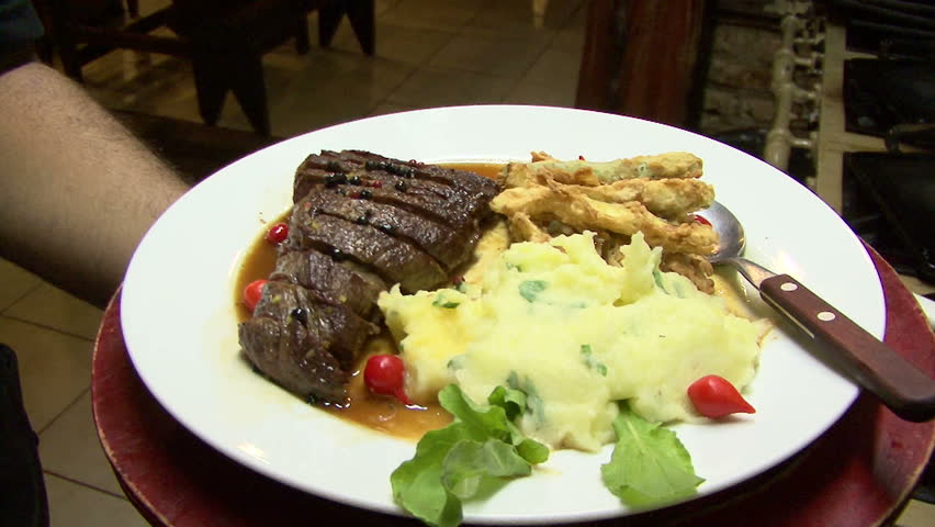 Waiter holding Brazilian food on a plate