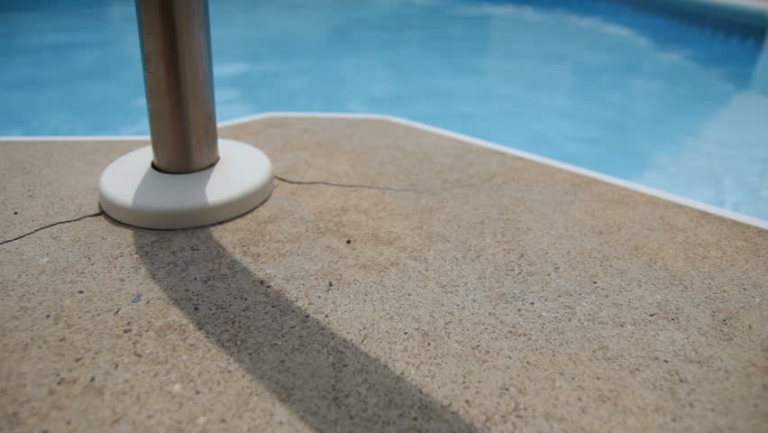Dolly of a railing on the edge of a swimming pool.