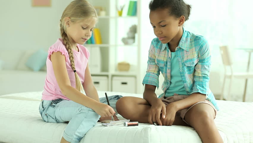 Preteen girls using cosmetics for the first time