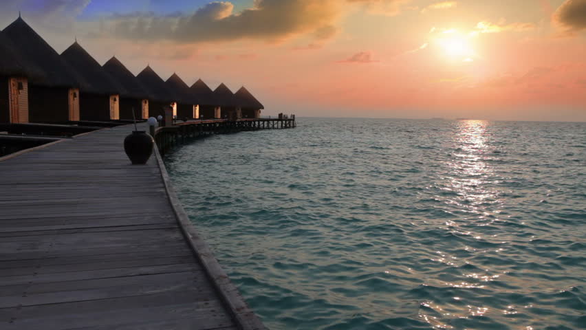 Villa on piles on water at the time sunset