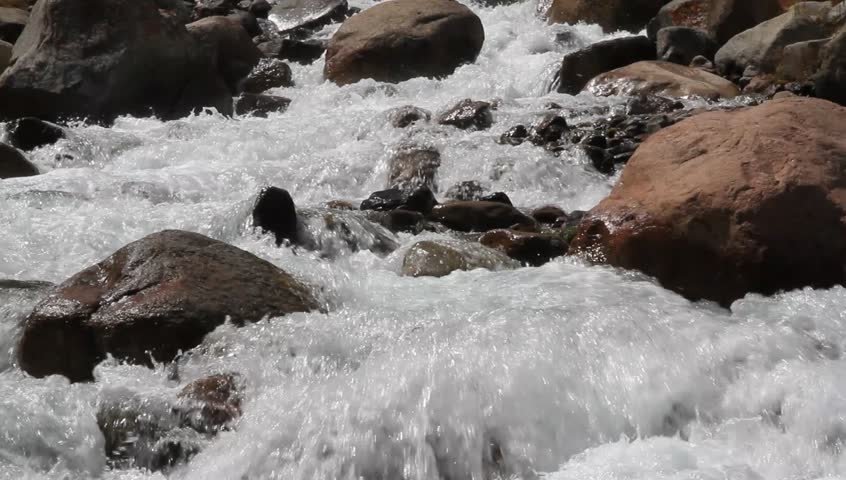The mountain river shined with the day sun promptly flows