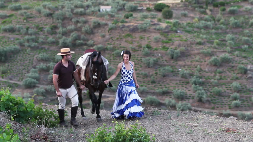 Man and woman walking with a horse in Andalusia, Spain