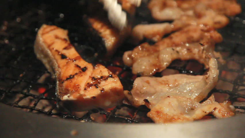 tongs reverse BBQ meat on grill