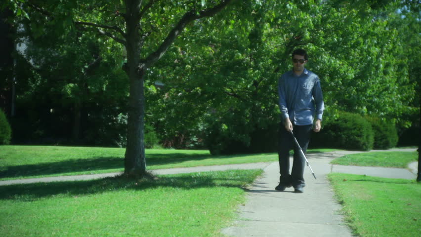 blind man walking with a stick