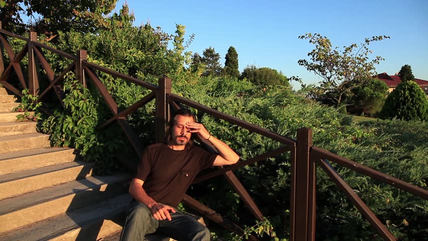 sad and thoughtful man sit stairs and looking phone