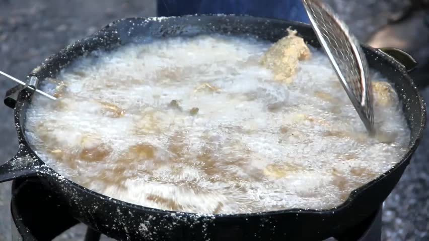 Food Cooking In Cooking Oil Stirred At Evening Cookout With Metal Utensil